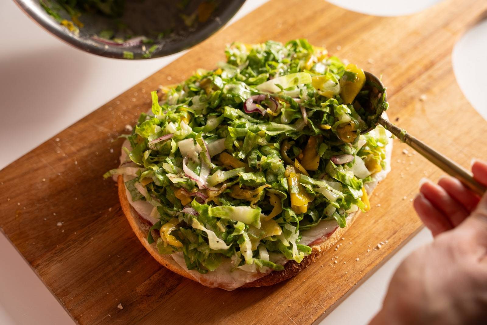 Adding greens to sandwich.