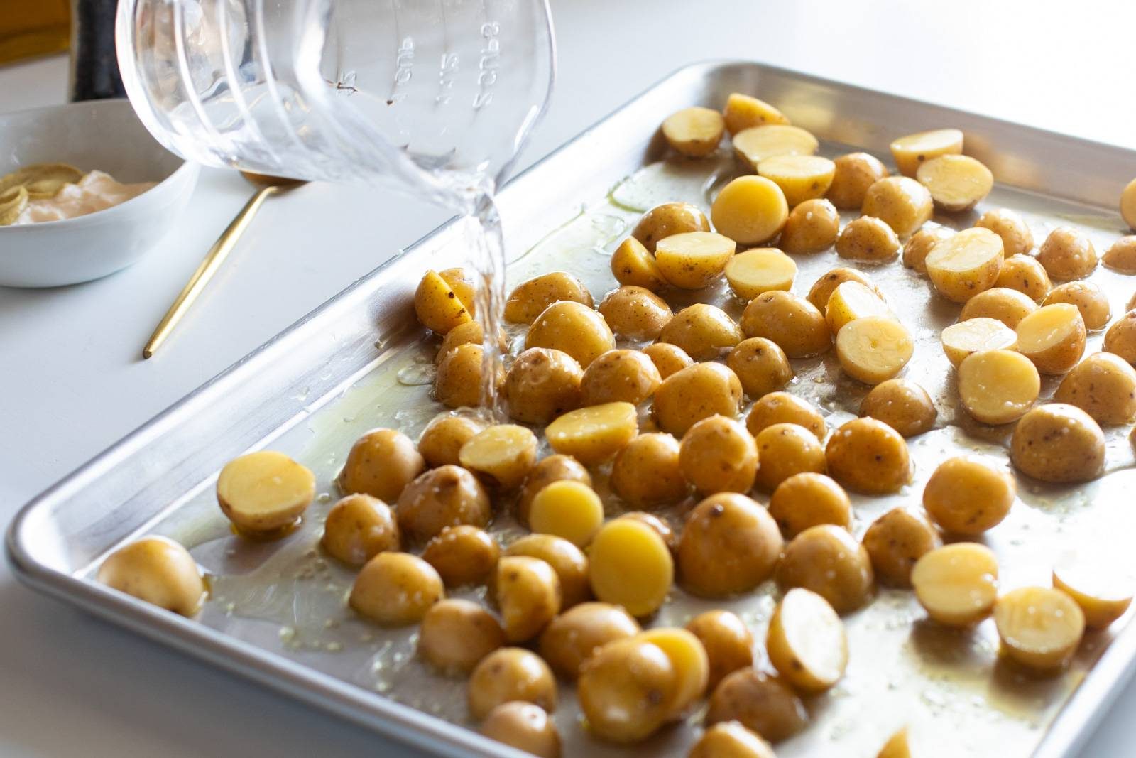 Potatoes and water on a sheet pan.