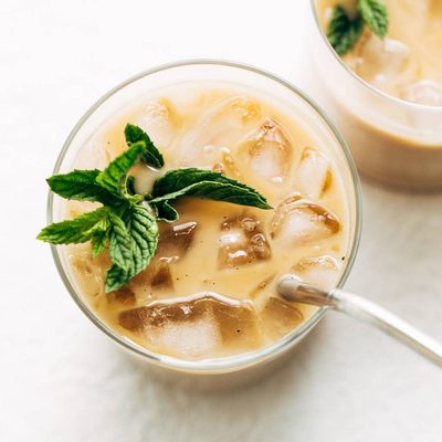 Vanilla mint iced coffee in two glasses, one with a metal straw.