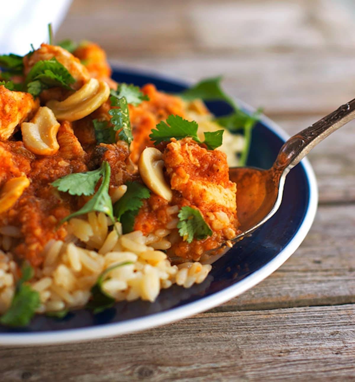 Cashew chicken in a bowl with a spoon.