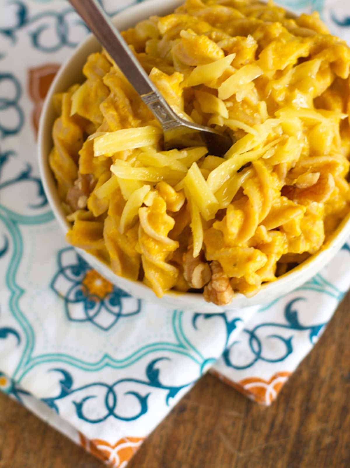 White cheddar mac n' cheese in a bowl on a colorful napkin.