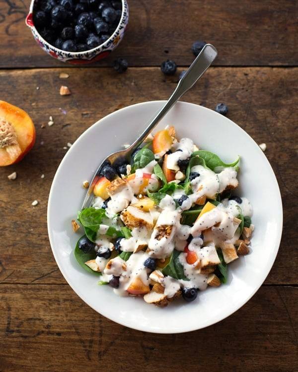 Chicken and nectarine poppy seed salad in a white bowl.
