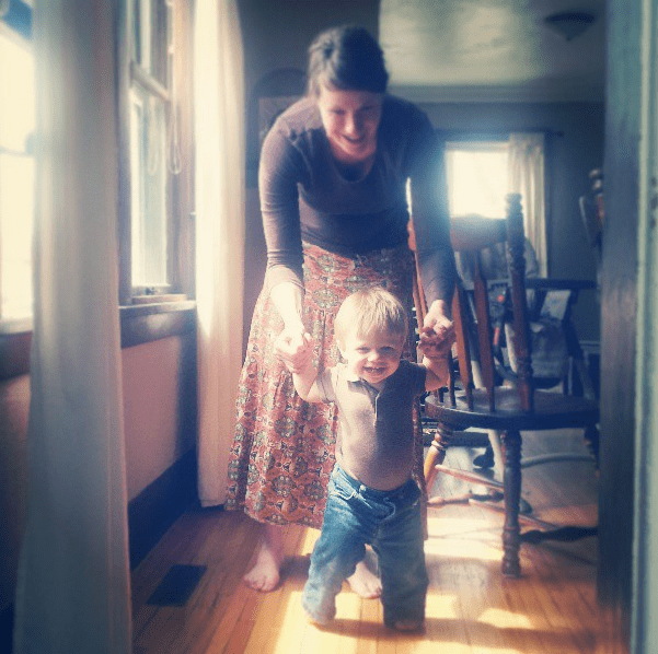Woman holding hands with a young boy.