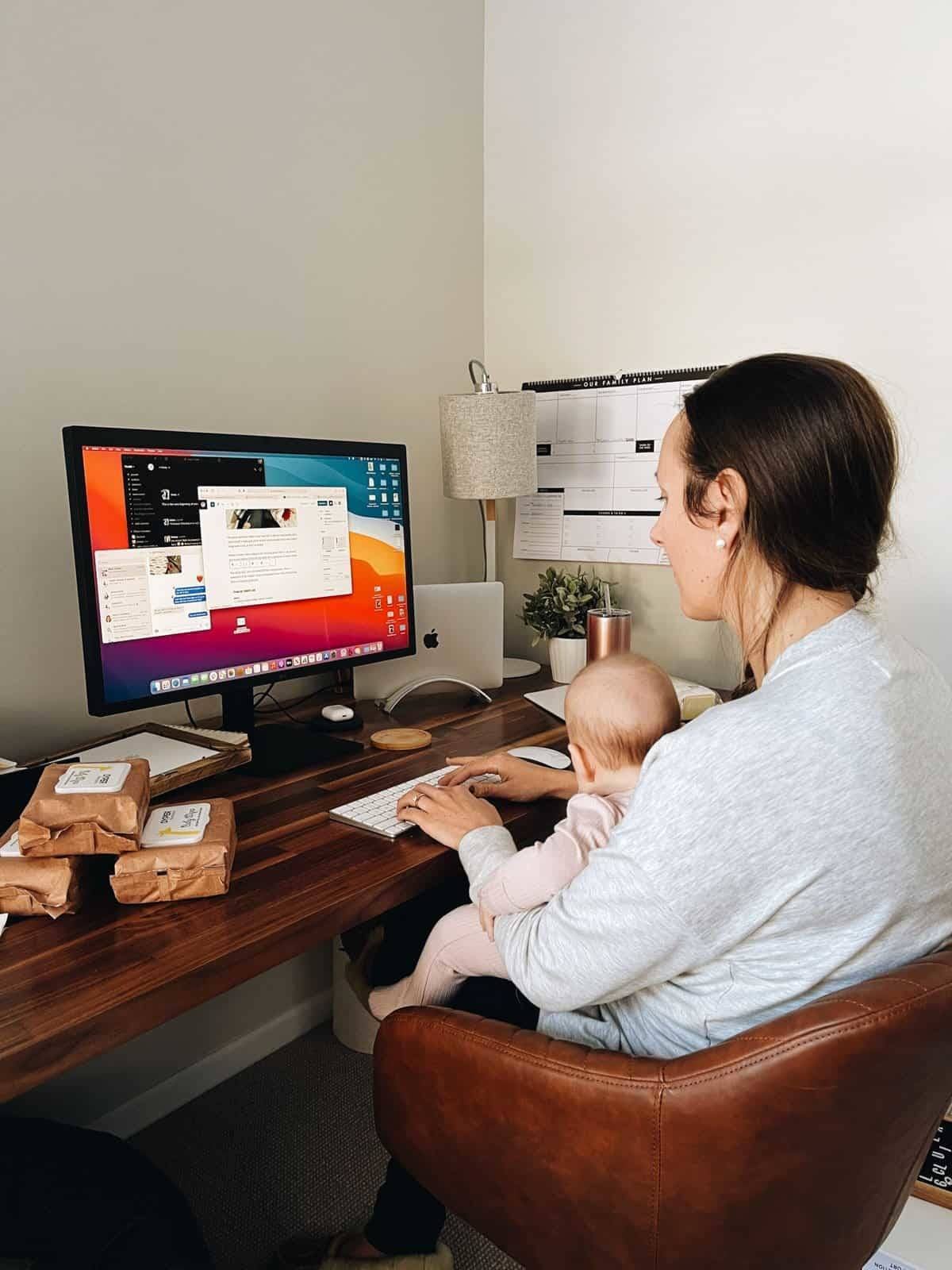 Lindsay working from home with baby in her lap.