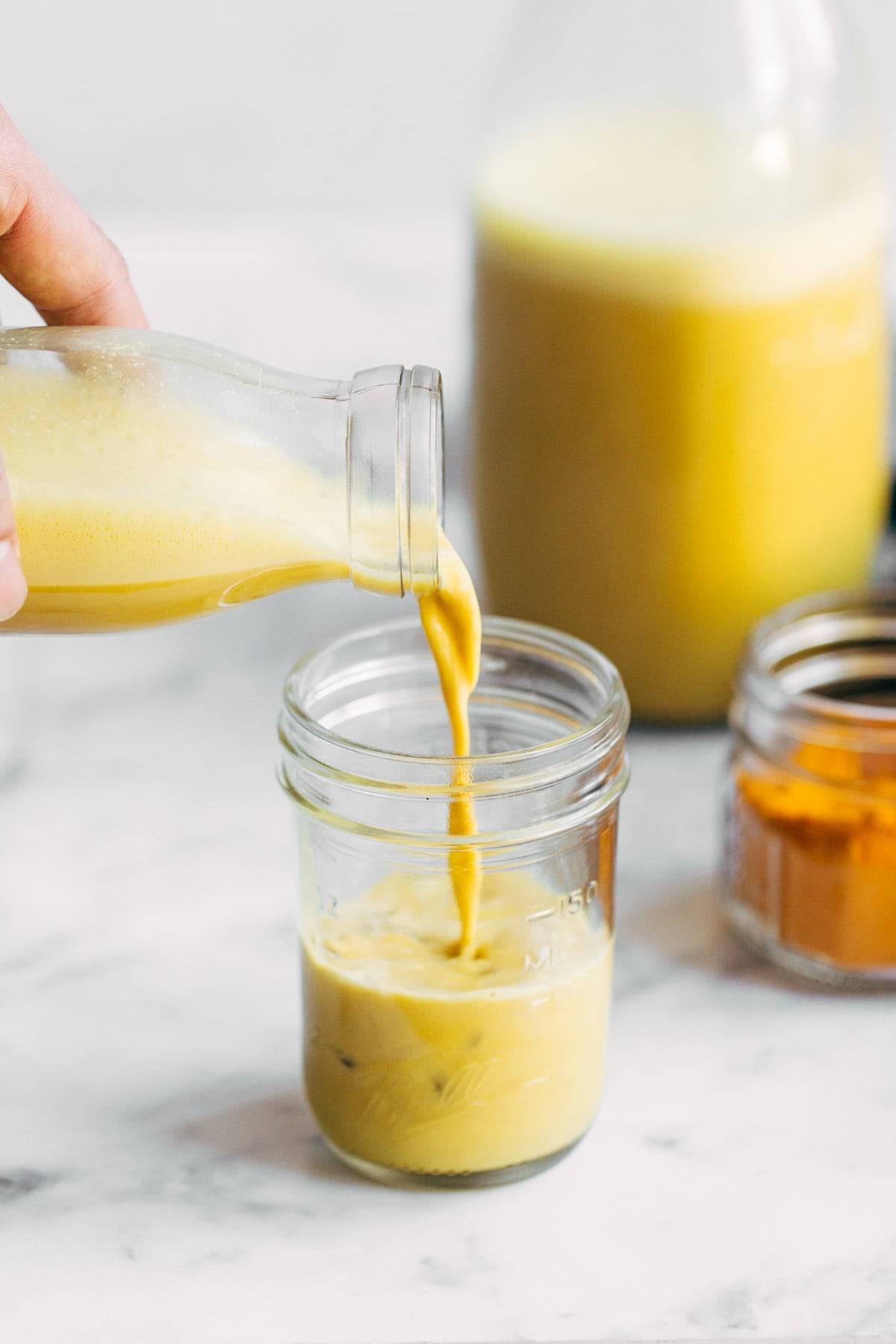 Golden milk latte being poured into a jar.
