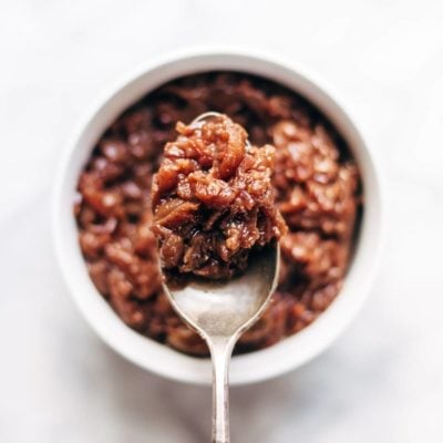Caramelized Shallot and Grape Chutney in a jar with spoon.
