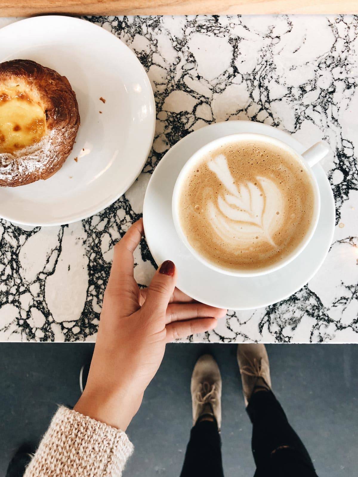Coffee in a cup with creamer made into a design on it.
