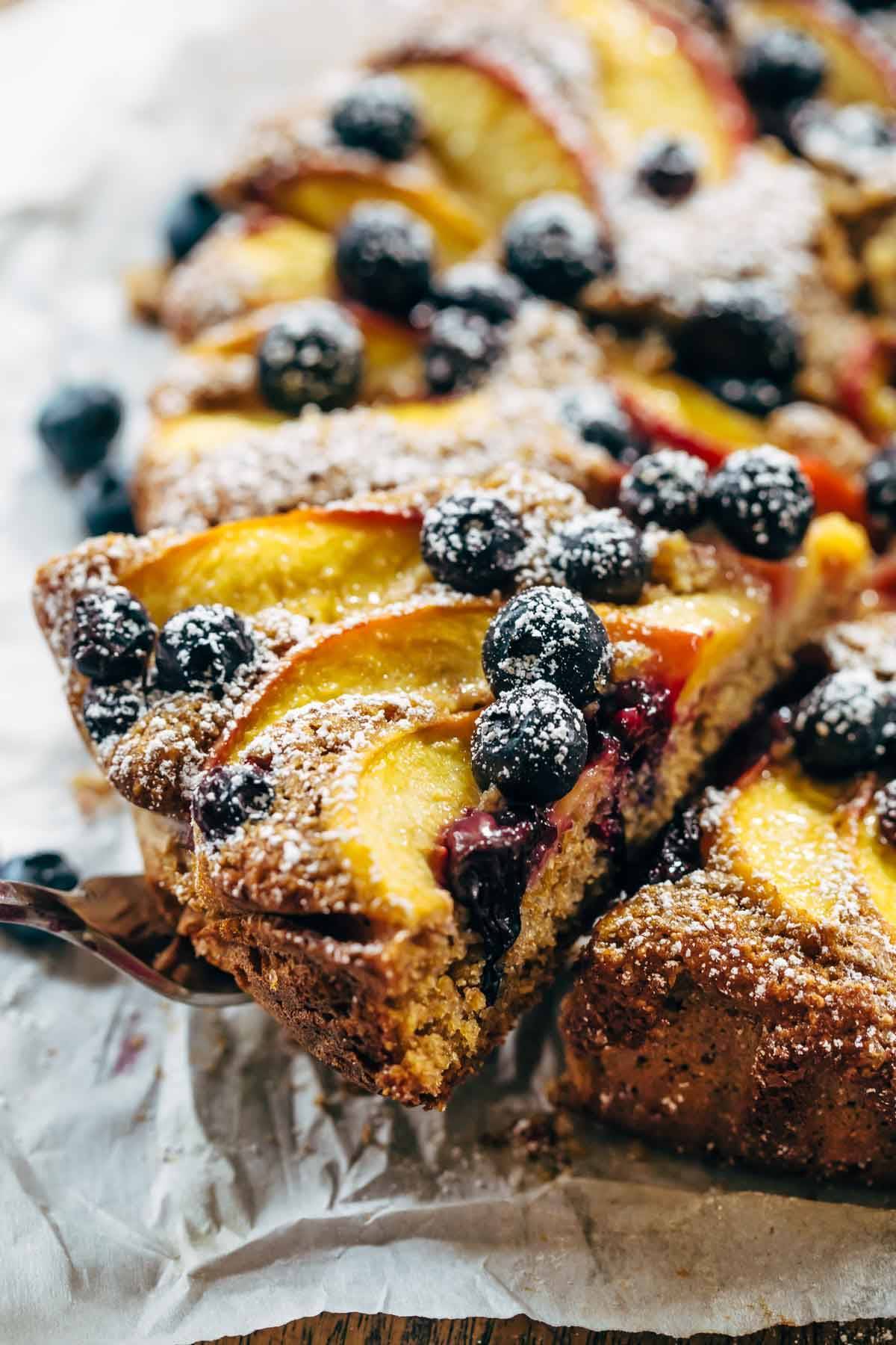 Blueberry Peach Cake recipe uses simple ingredients, whole wheat, no refined sugar, and has a STUNNING presentation. YUM! | pinchofyum.com Fresh Blueberry Peach Cake with blueberries and coconut sugar spread over it.
