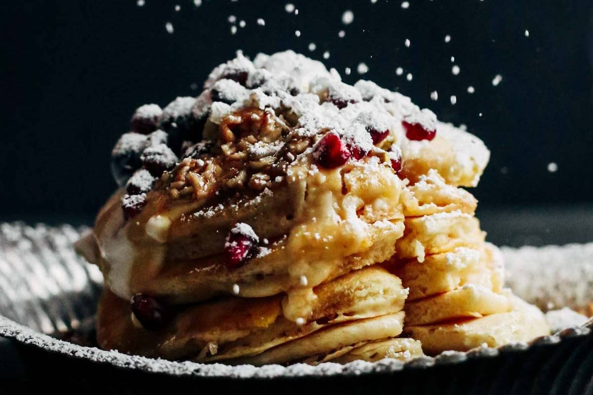 Pancakes with berries and powdered sugar.